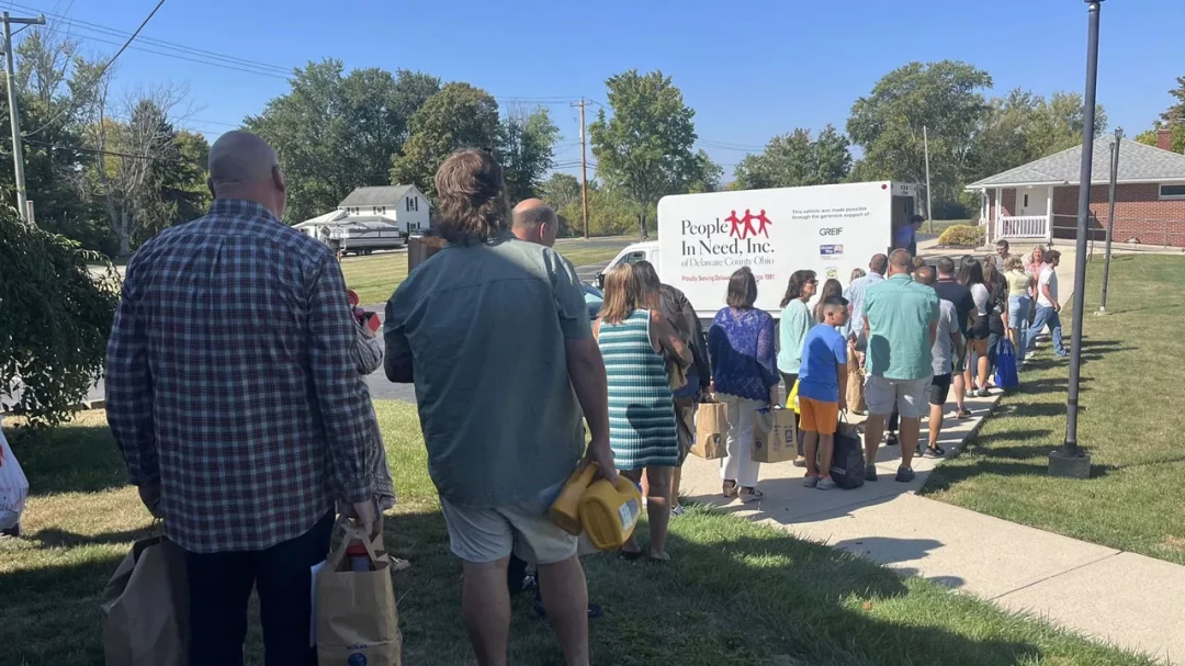 Community members lined up to receive food and supplies from outreach distribution truck
